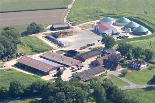 Luftaufnahme des Osterloh-Hofs in Steinkimmen, Ganderkesee: Wohnhaus, Werkstatt, Halle, Fahrsilo und Biogasanlage zwischen Feldern.